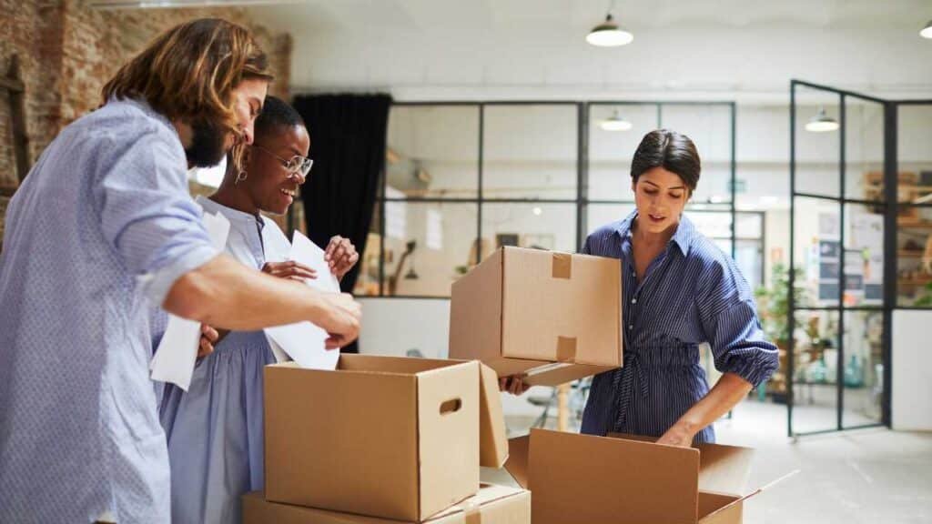 Movers using lifters and trolleys to safely load furniture for apartment relocation services in Abu Dhabi.